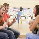 Young adults cheering in a bowling alley